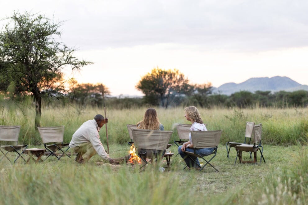 Gathering around a campfire in the bush during shoulder season travel