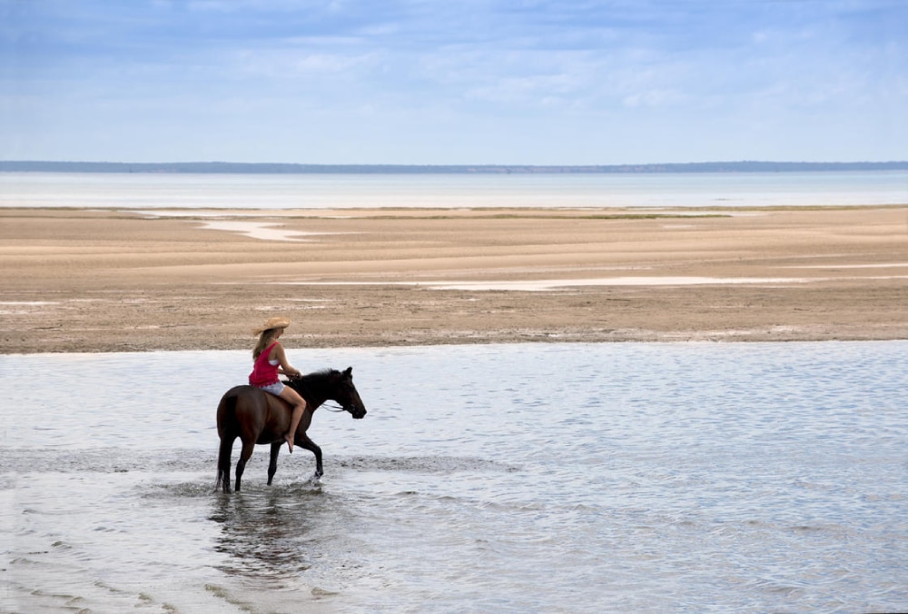 Woman on horseback on the beach