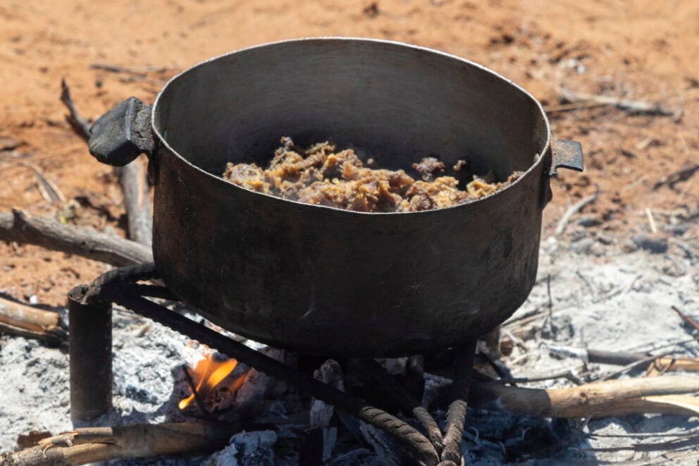 Seswaa, a traditional dish in Botswana, being cooked outdoors.