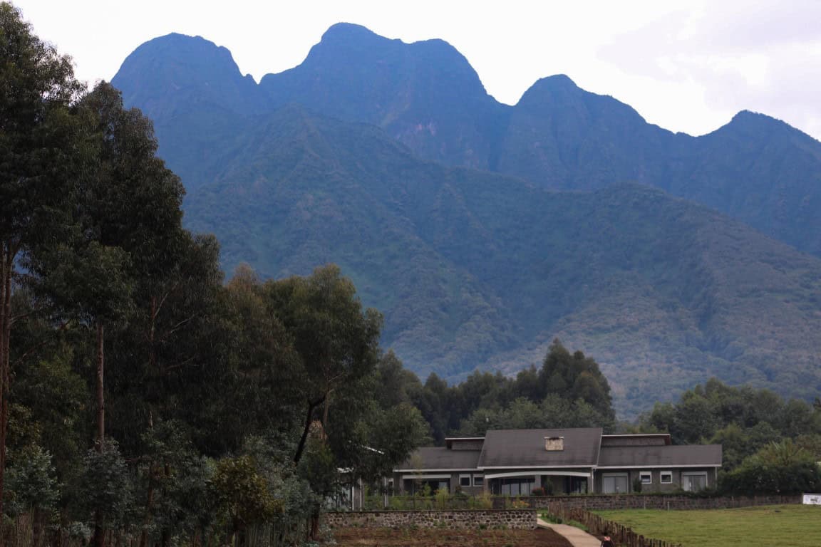 Exterior view of a lodge in Rwanda with a mountain backdrop 
