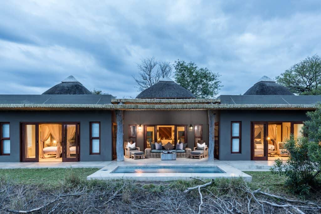 Single story safari villa with pool in front.