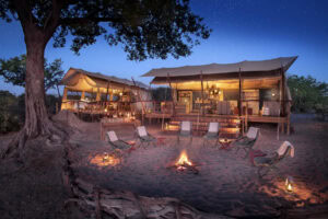 A safari camp in Botswana, campfire surrounded by chairs.