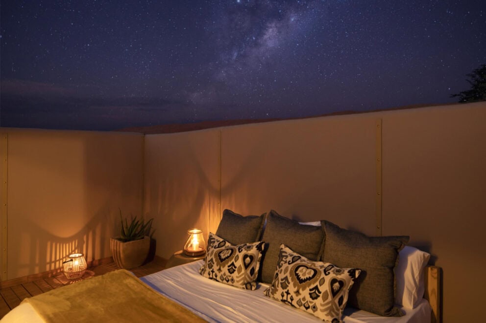 Star beds under the night sky at Kwessi Dunes, a luxury safari lodge.