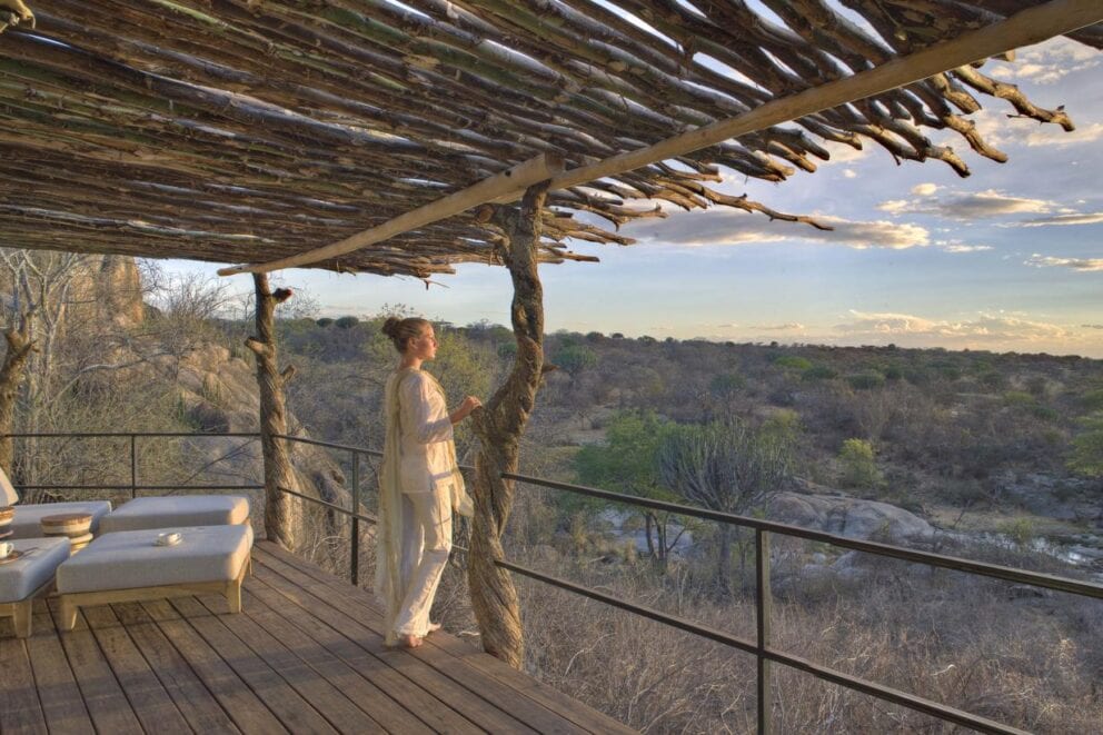 Woman looking over a deck of Mwiba Lodge